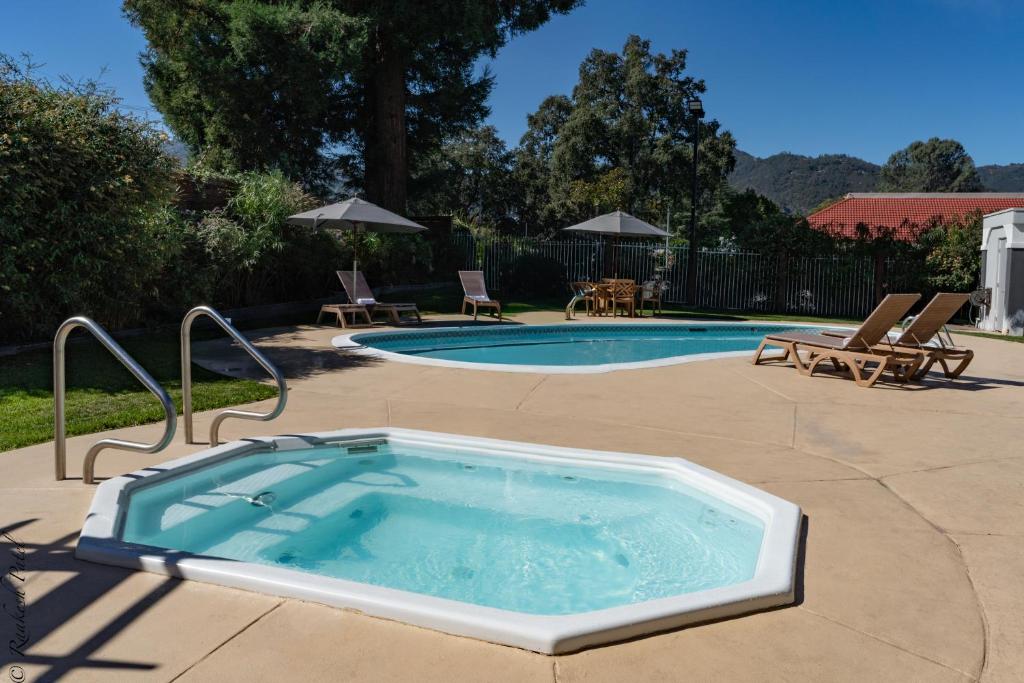 une piscine avec un jacuzzi dans une cour dans l'établissement The Orchard Hotel Ukiah Wine Country Free Breakfast, Pool, & Hot Tub, à Ukiah