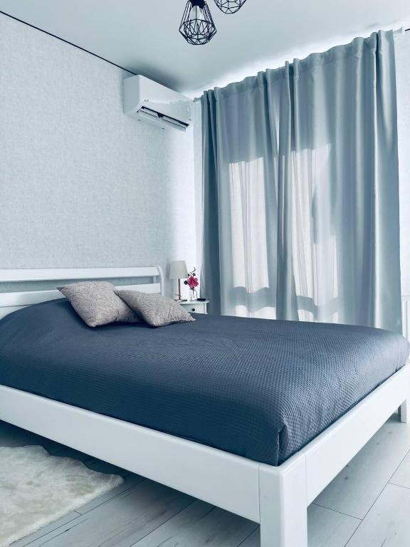 a bedroom with a large bed with blue sheets and a window at ЖК ДрімТаун Люкс апартаменти Євродвійка in Lutsk