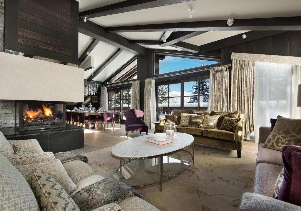 a living room with couches and a fireplace at Luxury Chalet Courchevel with Pool & Jacuzzzi in Courchevel