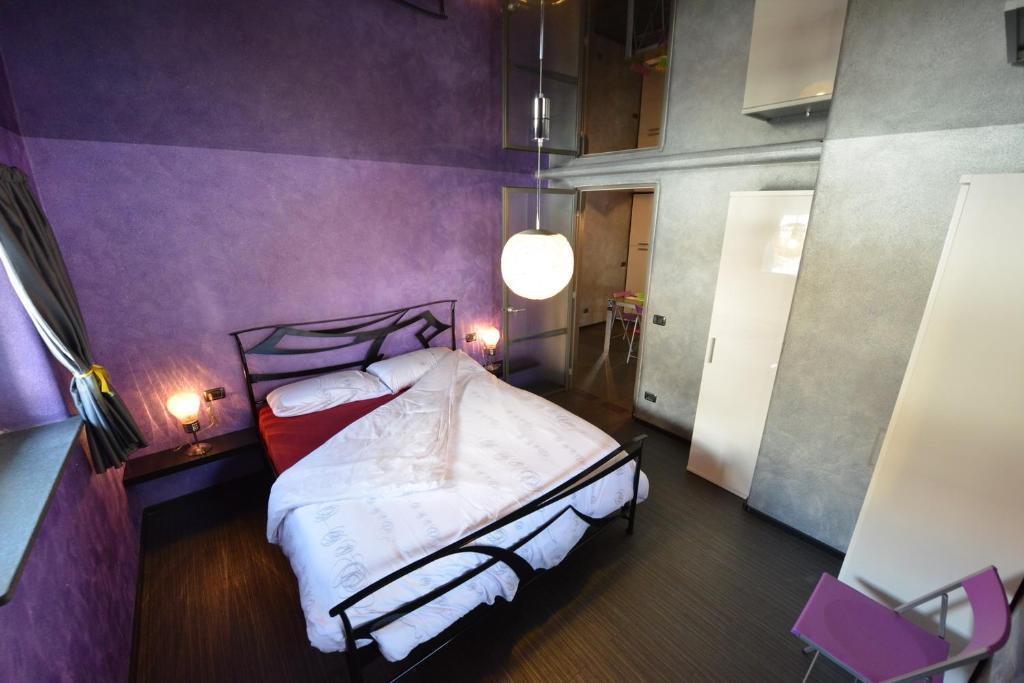 una camera con un letto con una parete viola di Maison de la Musique a Cogne