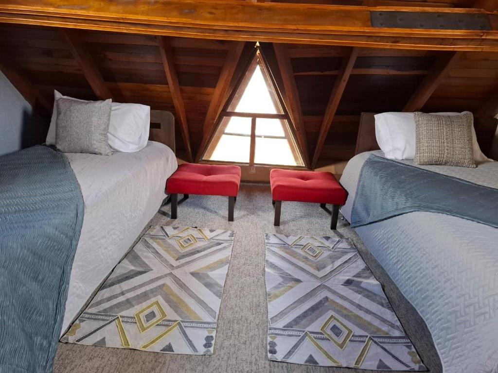 two beds with red seats in a room with a window at House Life in La Calera