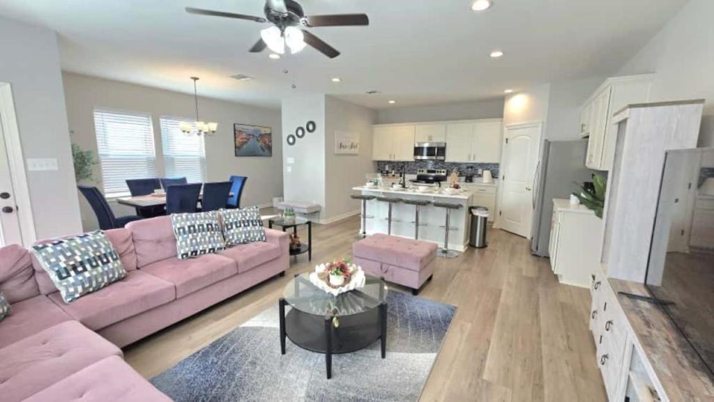 a living room with a pink couch and a kitchen at The Tigers Pathway House near LSU Stadium - BC1034 in Collegetown