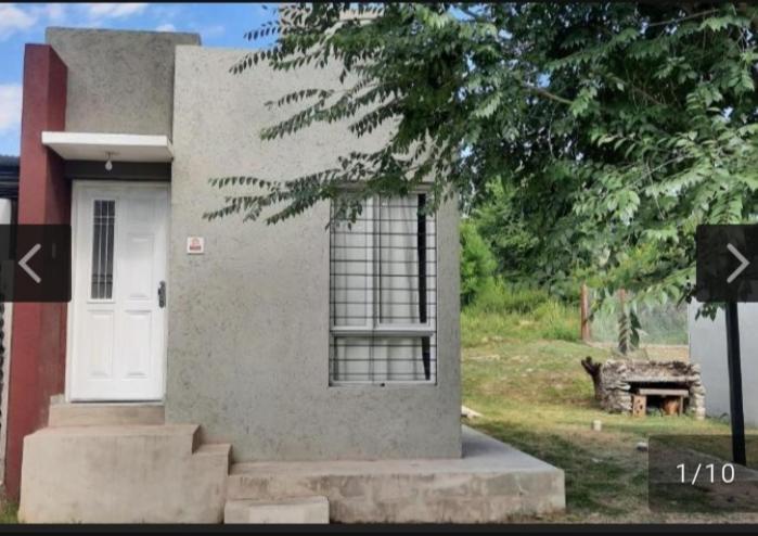 ein Haus mit einer weißen Tür und einem Baum in der Unterkunft San Antonio de Arredondo in San Antonio de Arredondo