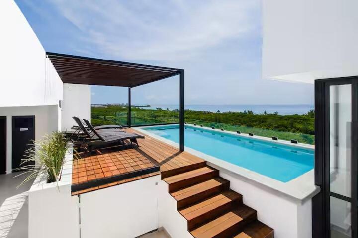 a house with a swimming pool and some chairs at Cozy Playa Escape Pool, Beach & 5th Avenue in Playa del Carmen
