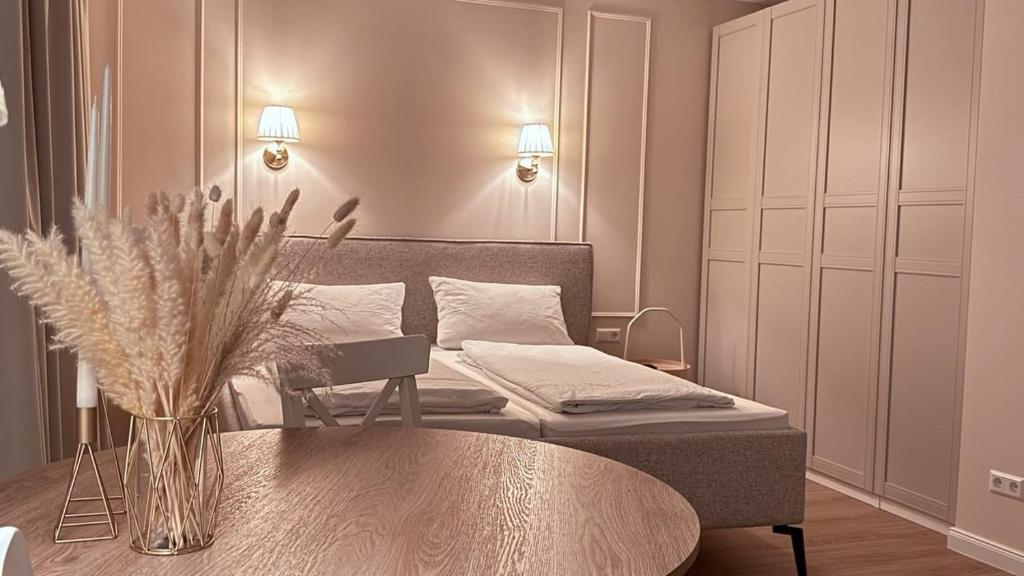 een slaapkamer met een bed en een tafel met een vaas met bloemen bij Apartments am Schwarzen Berge in Garbsen