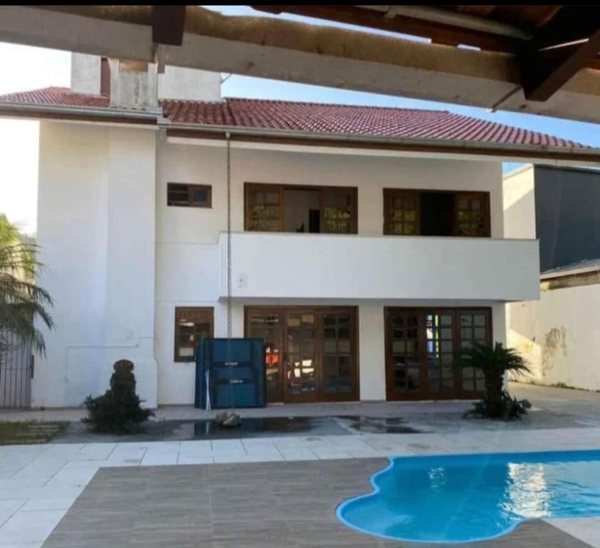 a house with a swimming pool in front of it at Hostel da Dani in Balneário Camboriú