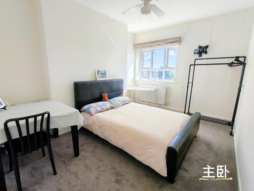 Un dormitorio con una cama grande y una mesa. en Fulham Palace Residence, en Londres