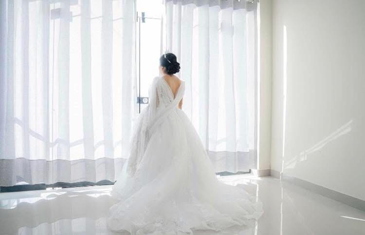 Eine Frau in einem Hochzeitskleid, die vor einem Fenster steht. in der Unterkunft El Gran Pajonal Hotel in Nueva Cajamarca