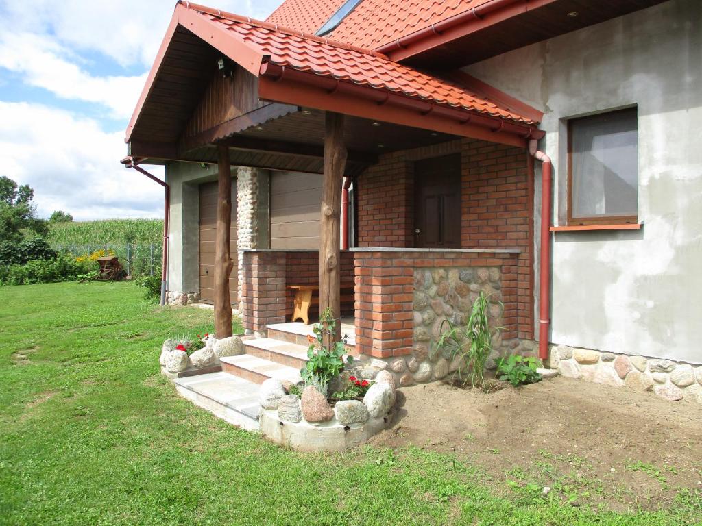 ein Backsteinhaus mit einem Kamin im Hof in der Unterkunft Hubertówka in Leszczewek