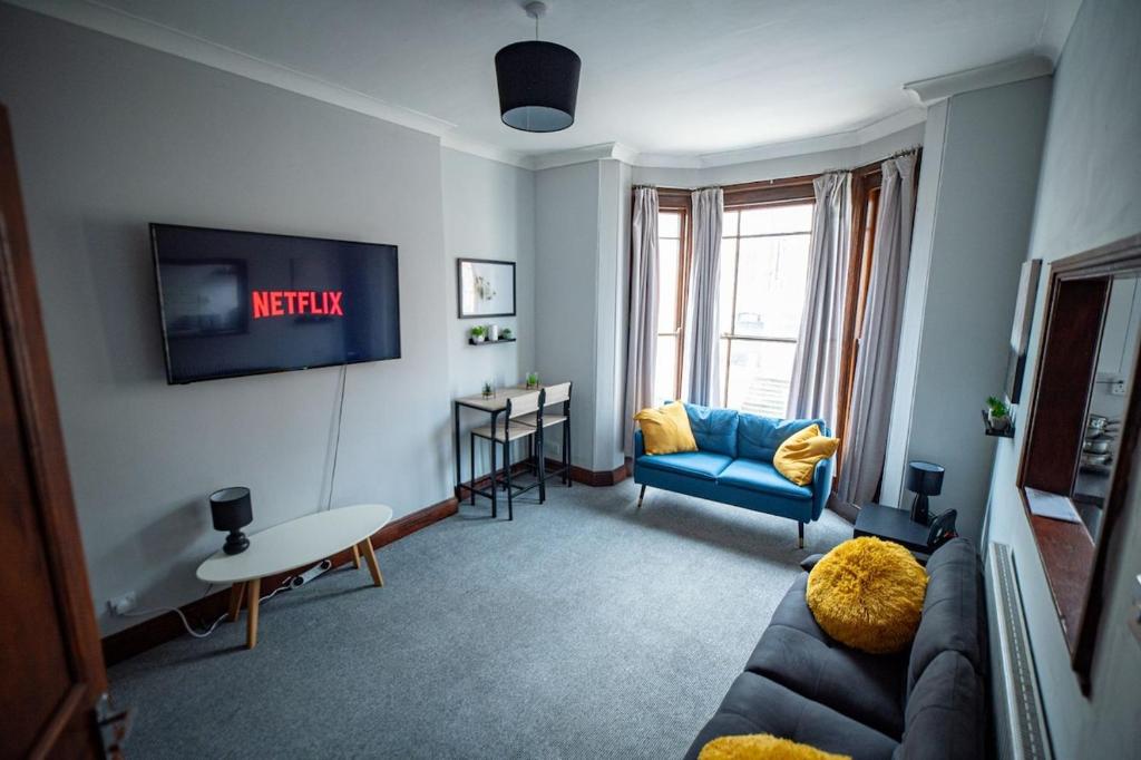 a living room with a couch and a tv at 1 BDR Apartment By Eason Stays Short Lets & Serviced Accommodation Lowestoft With Free parking in Lowestoft