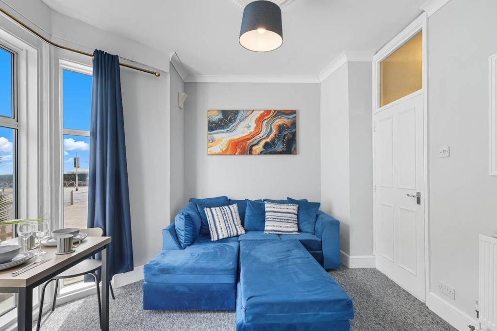 a living room with a blue couch and a table at Lowestoft Seaside Escape by Eason Stays, Free Parking next to Sea Front in Oulton