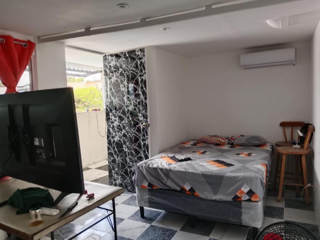 ein Schlafzimmer mit einem Bett und einem Fernseher in einem Zimmer in der Unterkunft Habitaciones Clásica en lo mejor de SS city in San Salvador