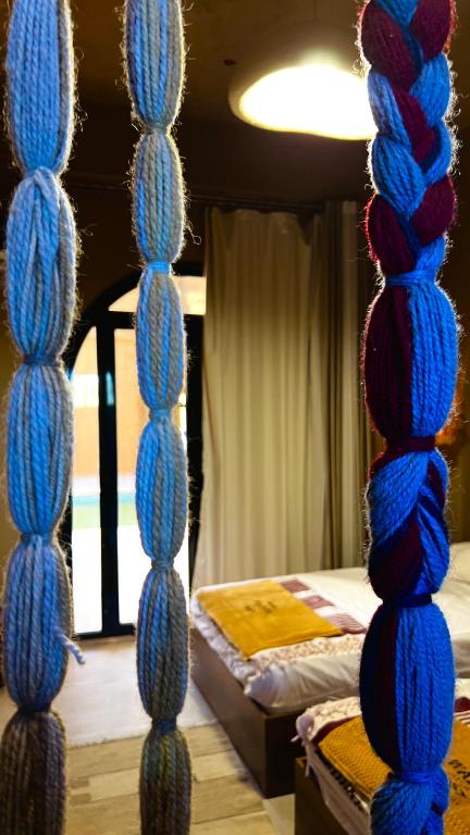 a room with a bed with blue knitted towers at Wazidi Resort in Siwa