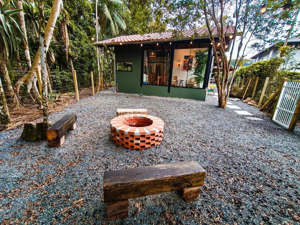 a building with a fire pit and benches in front of it at Refúgio cercado pela natureza em Pomerode in Pomerode