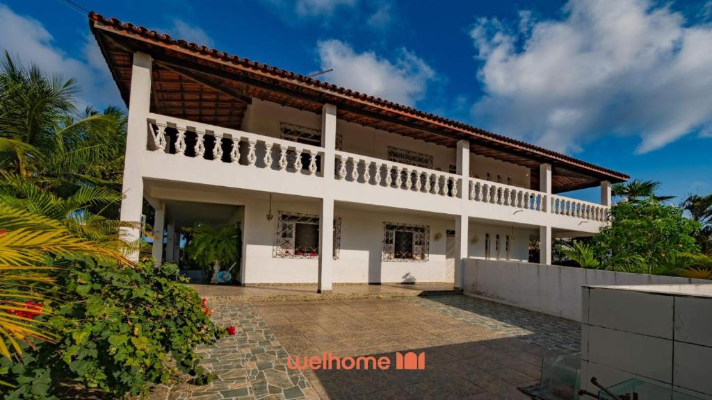 ein großes weißes Haus mit Balkon in der Unterkunft Casa em Salvador Praia do Flamengo jardim e paz in Salvador