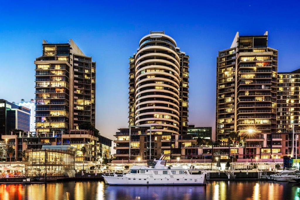 una ciudad con edificios altos y un barco en el agua en VAQUAY Glamptons In Docklands, en Melbourne