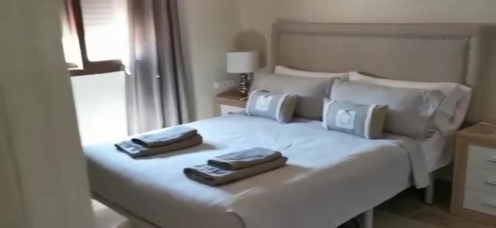 een slaapkamer met een wit bed met twee handdoeken erop bij Departamentos Márquez in Mar del Plata