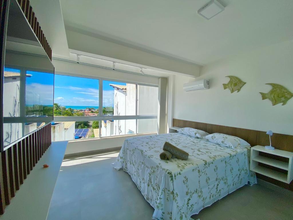 ein Schlafzimmer mit einem Bett und einem großen Fenster in der Unterkunft Suites da Manu in Morro de São Paulo