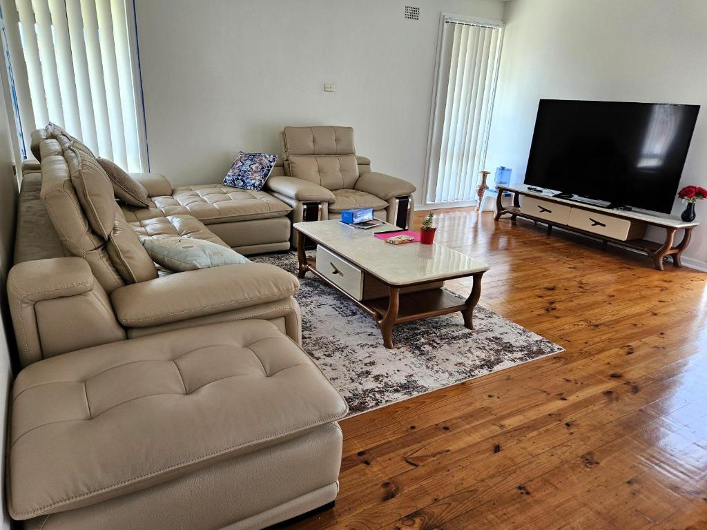 a living room with a couch and a tv at Campbelltown Family Retreat 3-Bedroom Home in Campbelltown