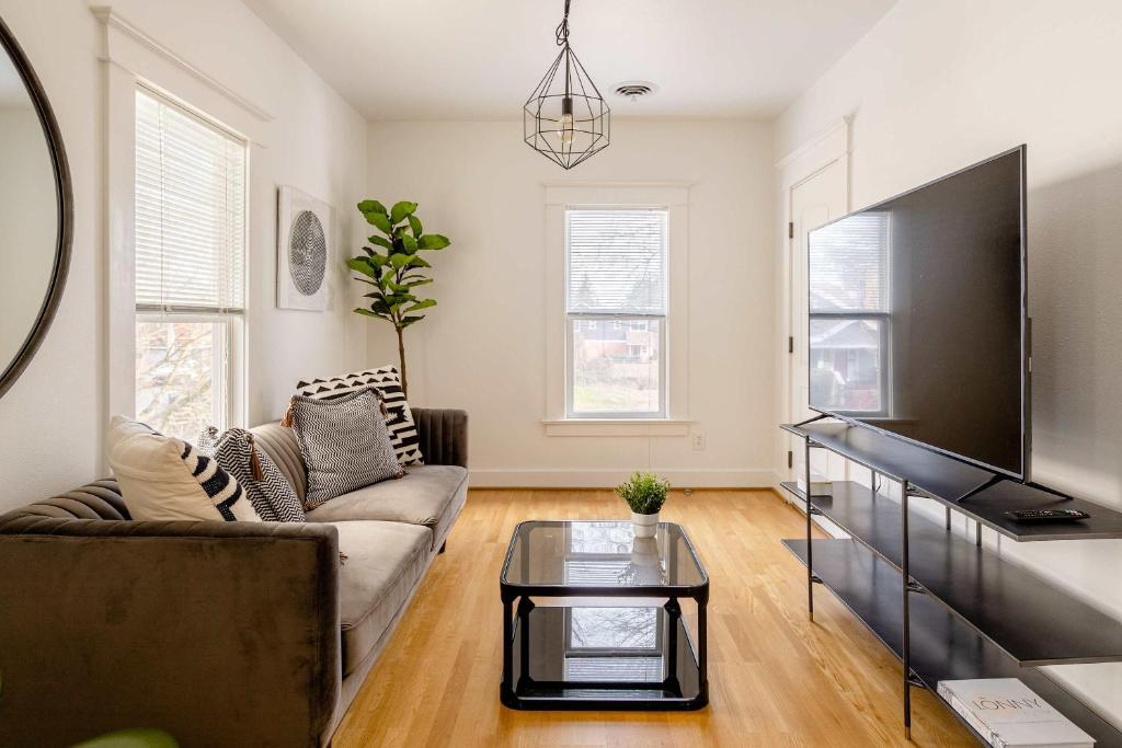 a living room with a couch and a flat screen tv at Hipster Vibe Apartment - Food Carts & Live Music in Portland