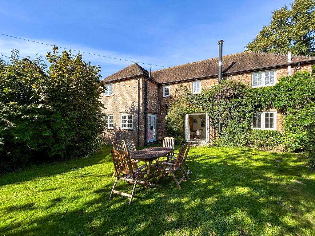 a table and chairs in the yard of a house at The Cottage - Uk50673 in Tangmere