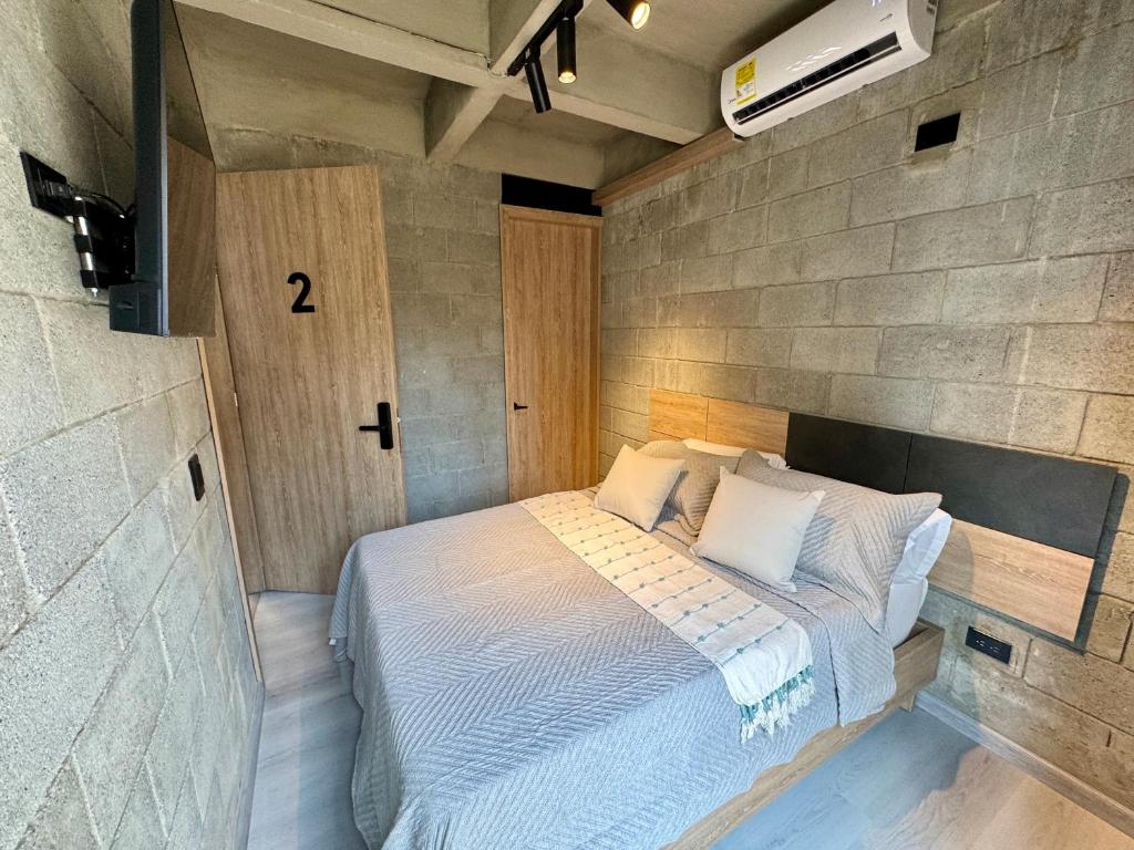 a small bedroom with a bed in a brick wall at Our Home Granada in Cali