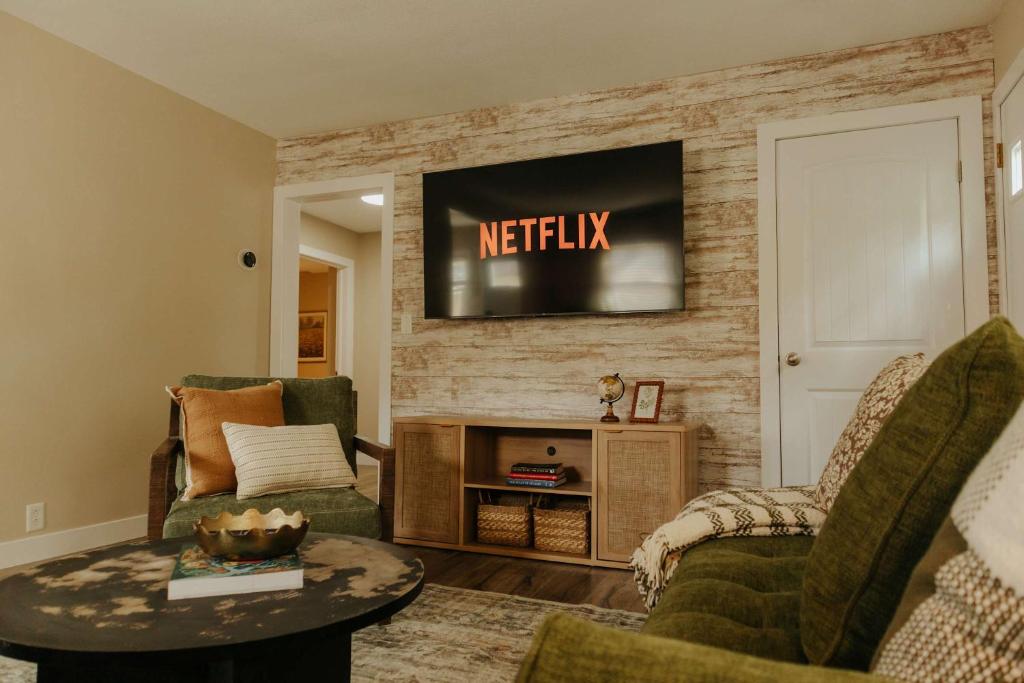 a living room with a television on a brick wall at The Atlas - Family-Focused Stay for Every Journey in Fargo