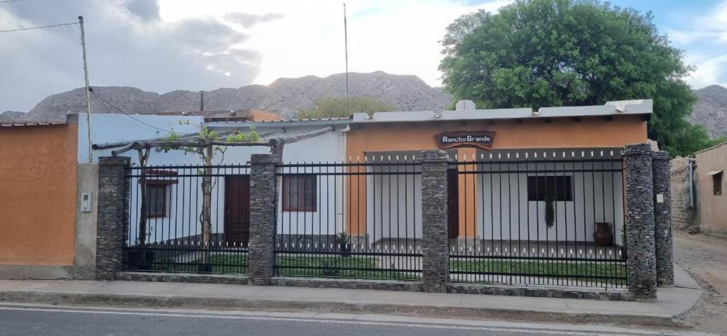 a fence in front of a building with mountains in the background at Rancho Grande in Santa María