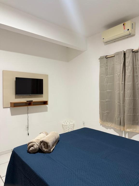 Habitación con cama con manta azul y TV. en Apartamento Mobiliado, en Santarém