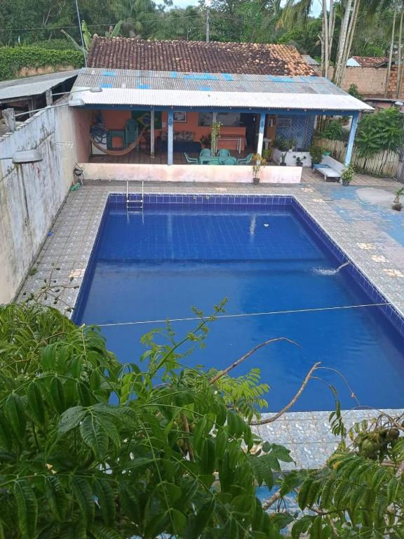 ein blauer Swimmingpool vor einem Haus in der Unterkunft kitnet Mosqueiro in Belém