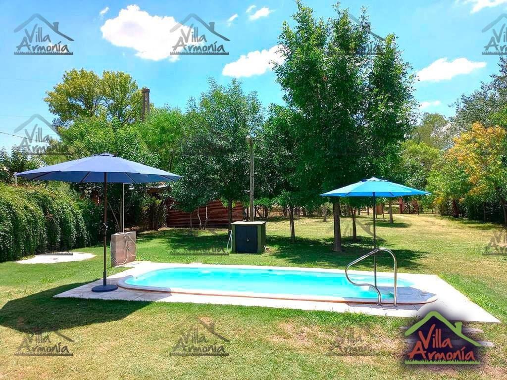 una piscina con 2 sombrillas en un patio en Villa Armonia, en La Picada
