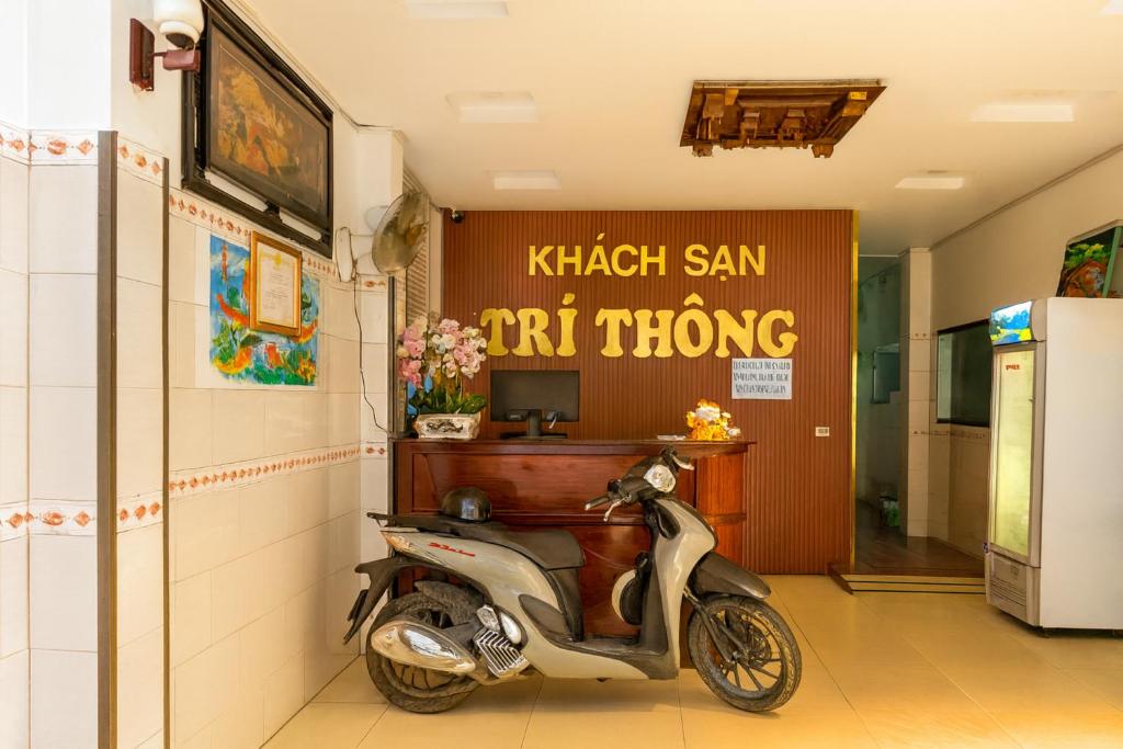 Un scooter está estacionado en un pasillo con una oficina. en Trí Thông Hotel, en Ho Chi Minh