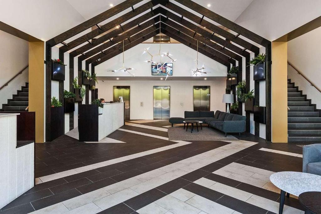 a lobby with stairs and couches in a building at VAQUAY Embassy In Abbotsford in Melbourne