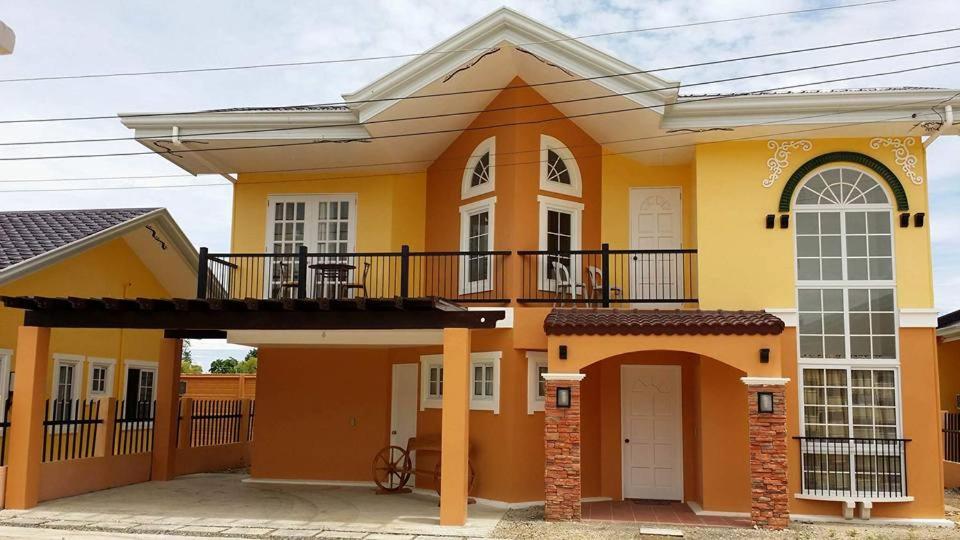 een groot geel huis met een balkon bij Panglao Ramyer Villa 1 in Sampong