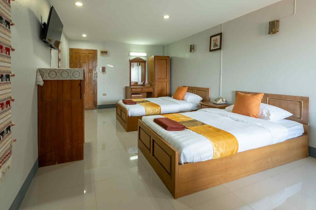 a bedroom with two beds and a television in it at โรงแรมเชียงดาวอินน์ Chiangdaoinnhotel in Chiang Dao