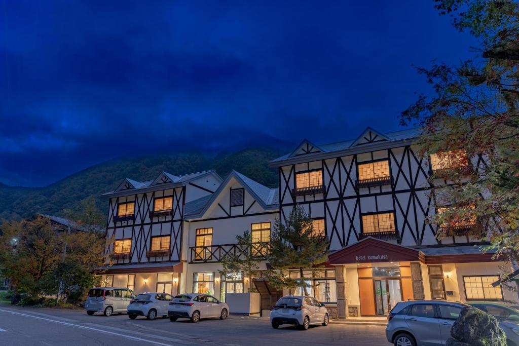 un grande edificio con auto parcheggiate di fronte di Komakusa Hotel a Matsumoto