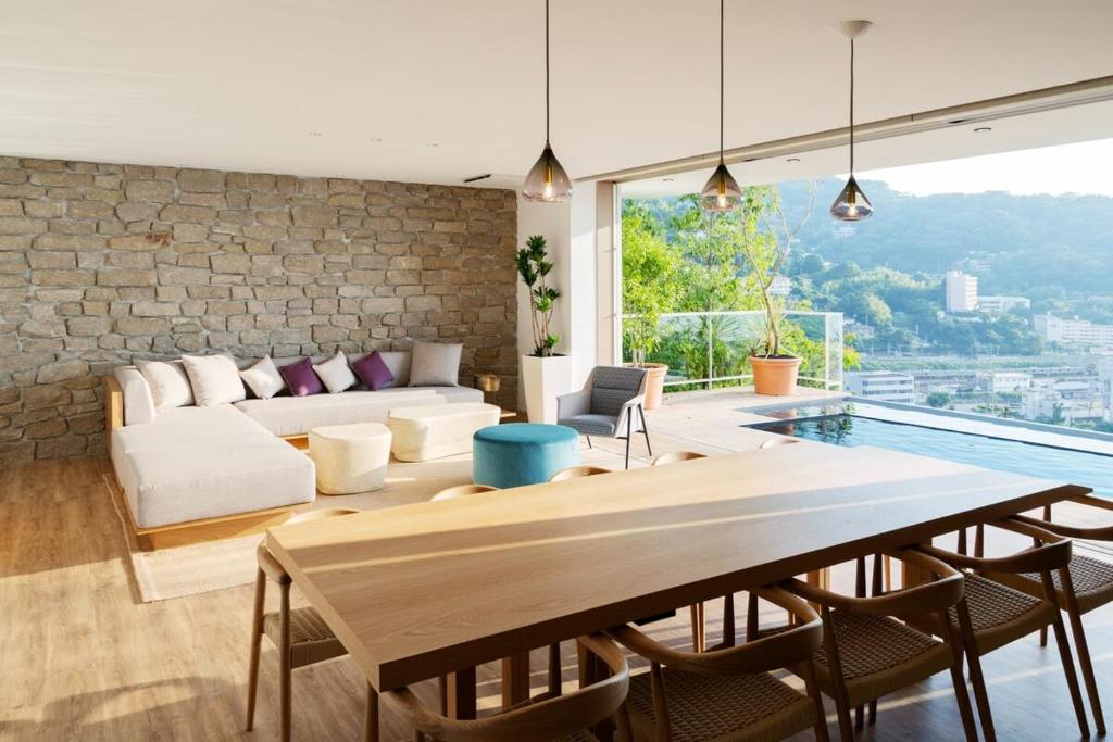 Asnova Resort FLORES ATAMI في أتامي: غرفة معيشة مع أريكة وطاولة