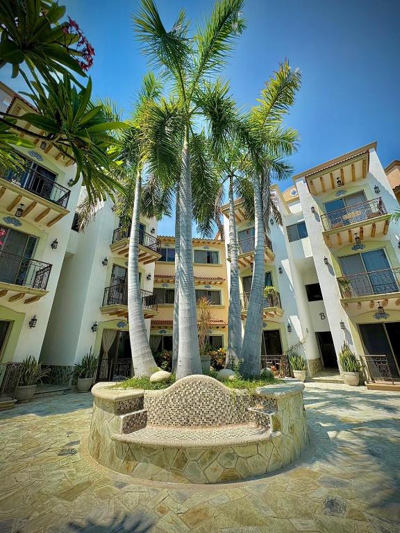 a group of palm trees in front of a building at Penthouse en Huatulco con alberca, balcón, 5 min playa in Santa Cruz Huatulco
