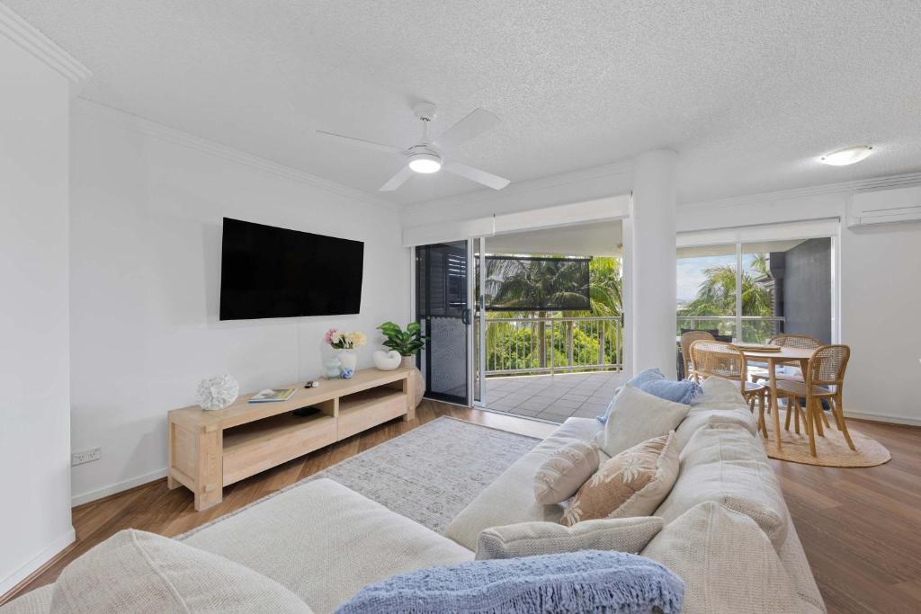 a living room with a couch and a tv at Ocean Vista Retreat - Walk to Mooloolaba & Alex in Mooloolaba