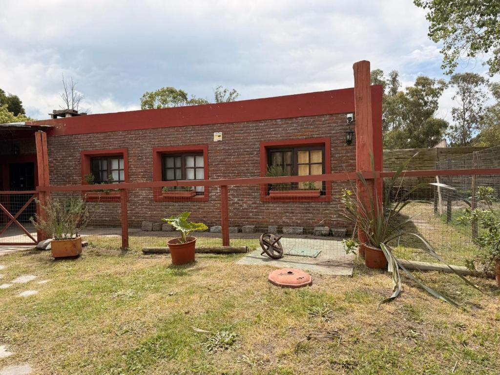 a brick house with a red roof at Casa cómoda en La Barra in Punta del Este