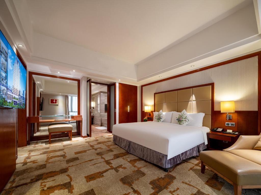 a hotel room with a bed and a couch at Cinese Hotel Dongguan Shijie in Dongguan