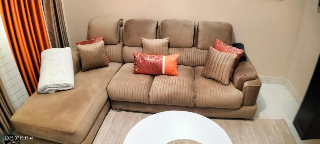 a brown couch with pillows on it in a living room at Embu Pacific Homes Two Bedroom in Embu