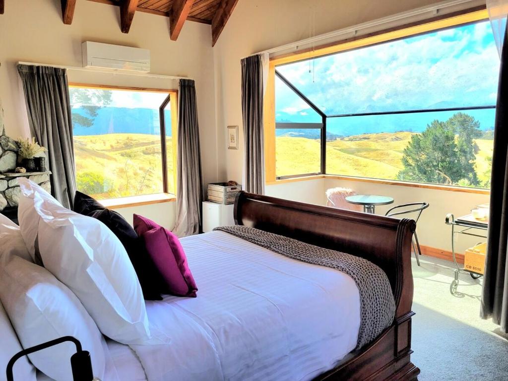 a bedroom with a bed and a large window at Rose Ridge Retreat in Upper Moutere