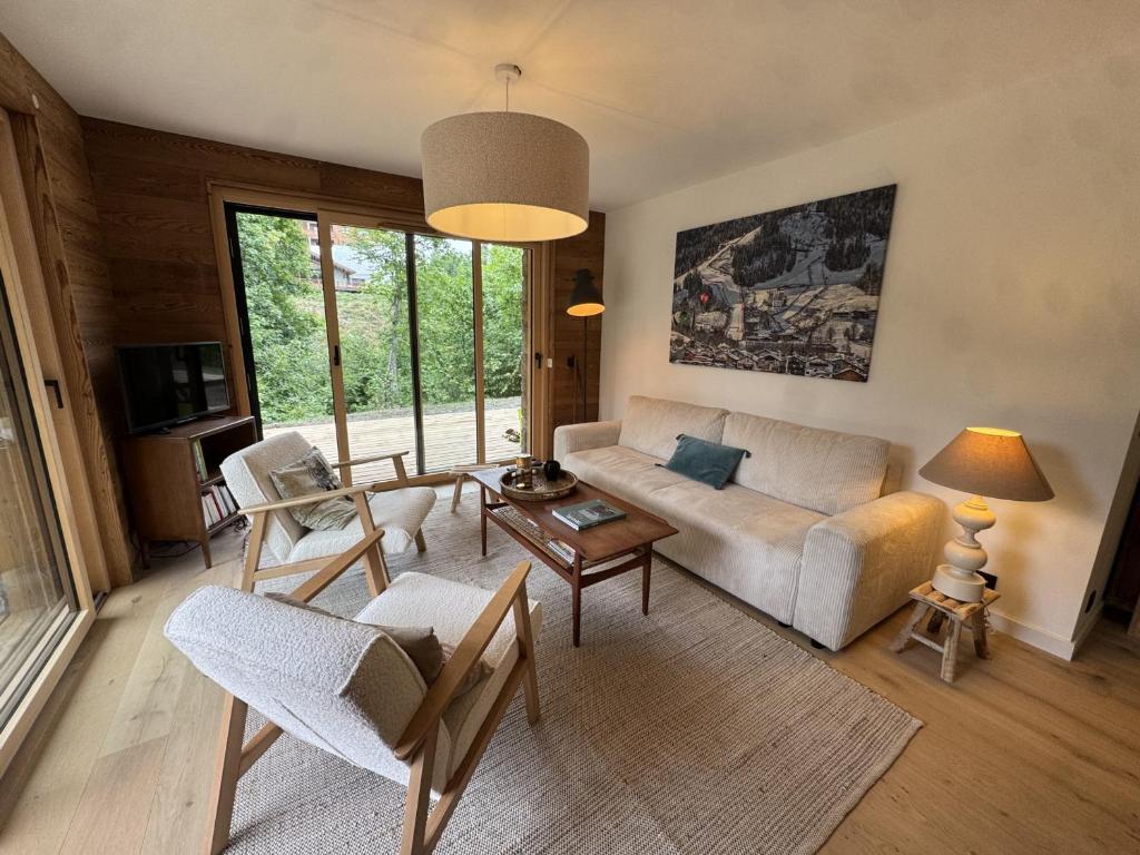 雷加霍斯达哈施Appartement 3 Chambres avec Terrasse et Parking à Arâches-la-Frasse, Animaux Bienvenus - FR-1-836-41的客厅里有一张沙发和一张桌子。