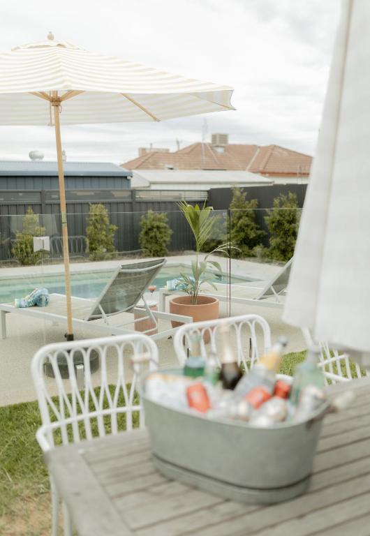 a container of drinks on a table next to a pool at California 'Luxe Boho' with Pool in Echuca