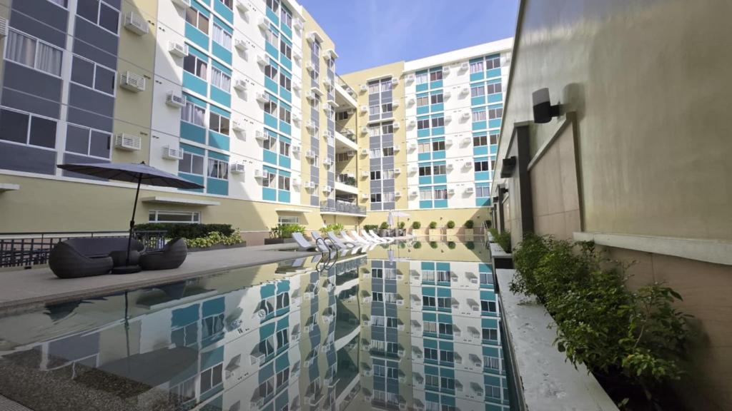 a building with a reflecting pool in front of a building at Urban Oasis Cozy Studio at Berkeley Suites South Forbes Nuvali in Silang