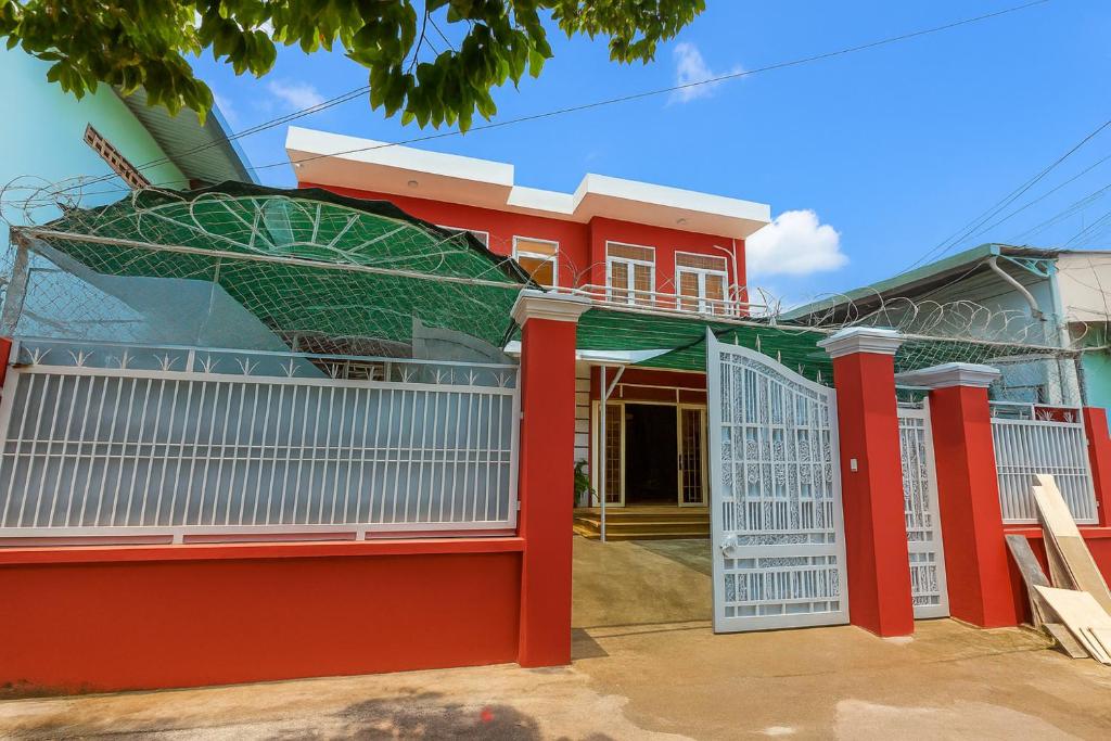 a red and white house with a gate at REDHOME DORM in Ho Chi Minh City