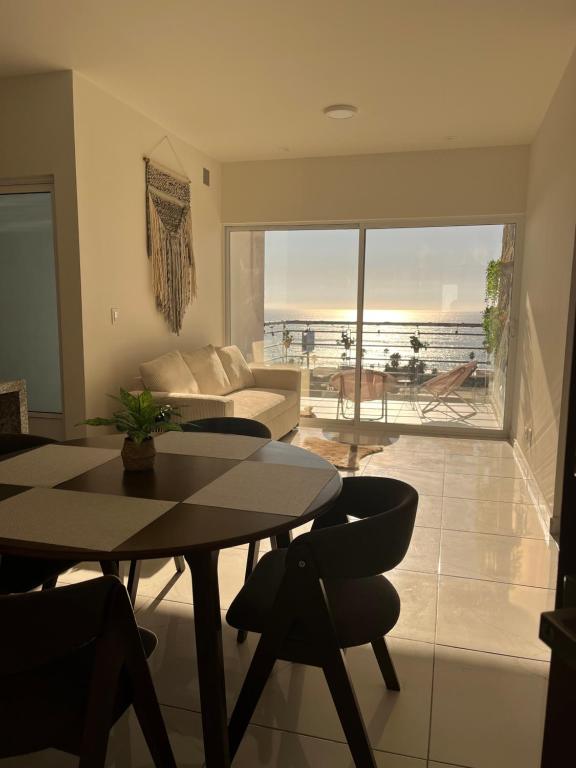 a living room with a table and chairs and a view of the ocean at Rosarito Sol y Mar Getaway in Rosarito Beach