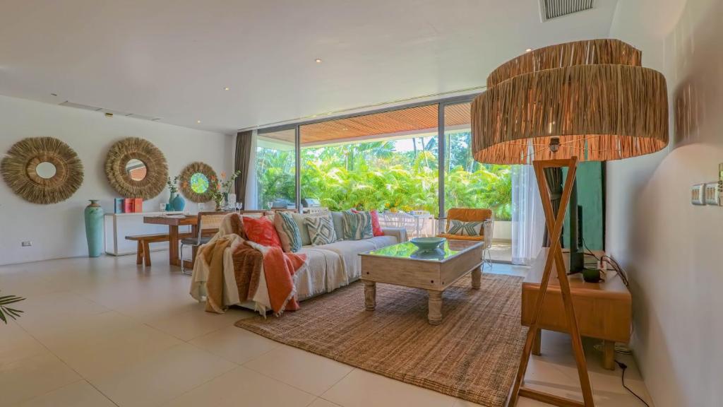 una sala de estar con un sofá y una mesa en Recently renovated 3BR apartment near Layan Beach, en Phuket