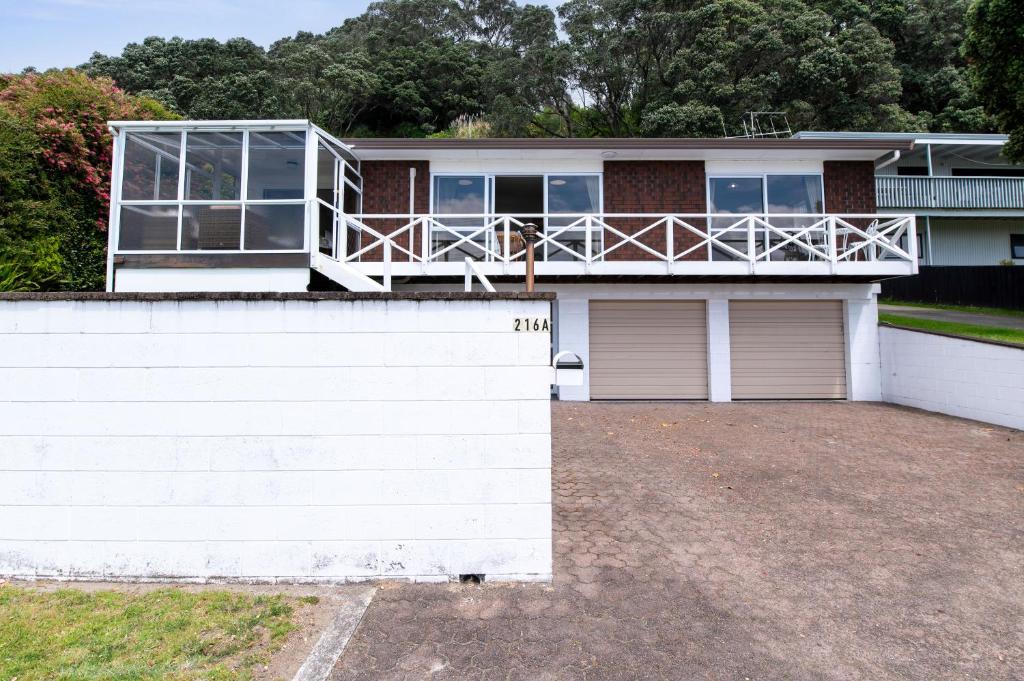a house with a balcony on top of it at Ohope Ocean Breeze Escape in Ohope Beach